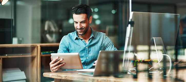 Man working on tablet and laptop