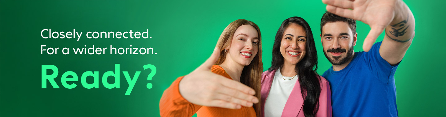 A group of three people smile at the camera and extend their hands invitingly.