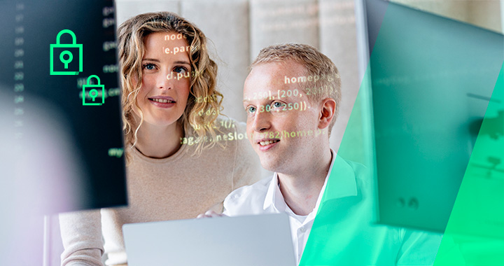 Zwei Personen schauen gemeinsam auf einen Monitor mit sichtbarem Code und arbeiten konzentriert an einem Laptop.