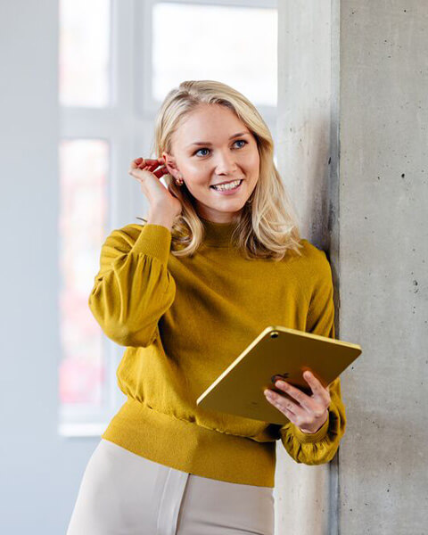 Freundliche Studentin mit dem Tablet in der Hand.