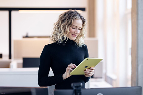 Freundliche Frau mit dem Tablet in der Hand.