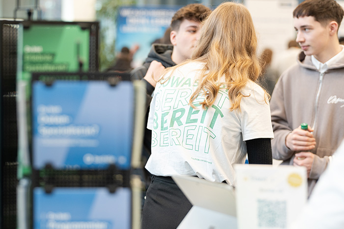 Menschen unterhalten sich auf einer Messegelände.