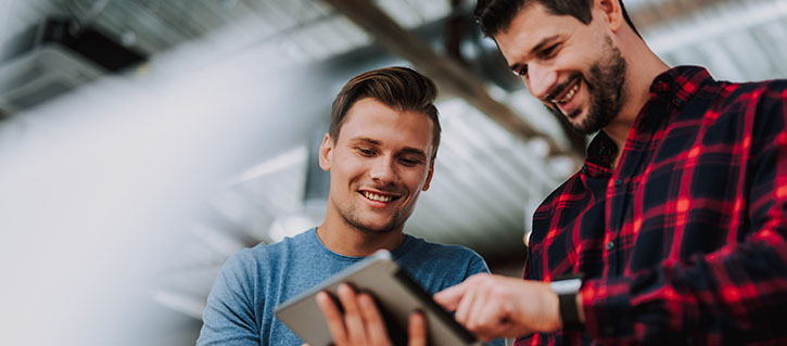 Two men looking at a tablet