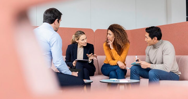 Mehrere Personen diskutieren sitzend in einem Besprechungsraum