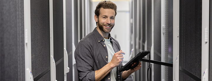 Ein glücklicher Mann arbeitet in einem Serverraum.